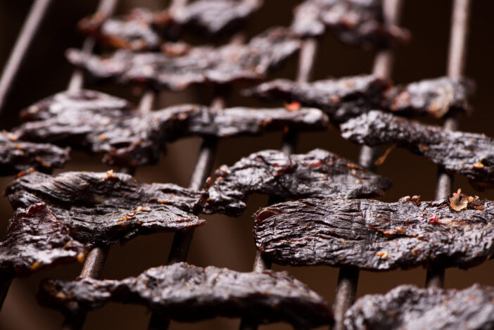Beef Jerky on wooden background close up