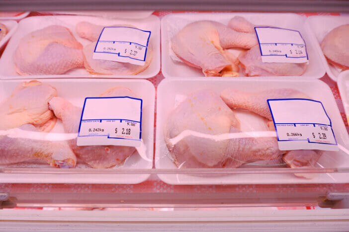 Packaged fresh chicken leg for sale in supermarket, displayed on shelves; pre packed meat