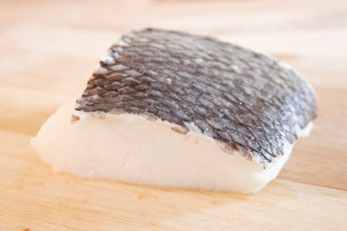 Raw chilean sea bass on a cutting board.