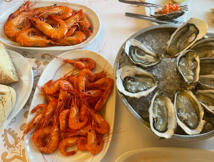 Red ocean Shrimps boiled and grilled, fresh oysters served on white plates in a restaurant