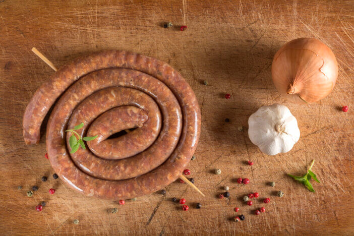 Raw sausage on wooden cutting board