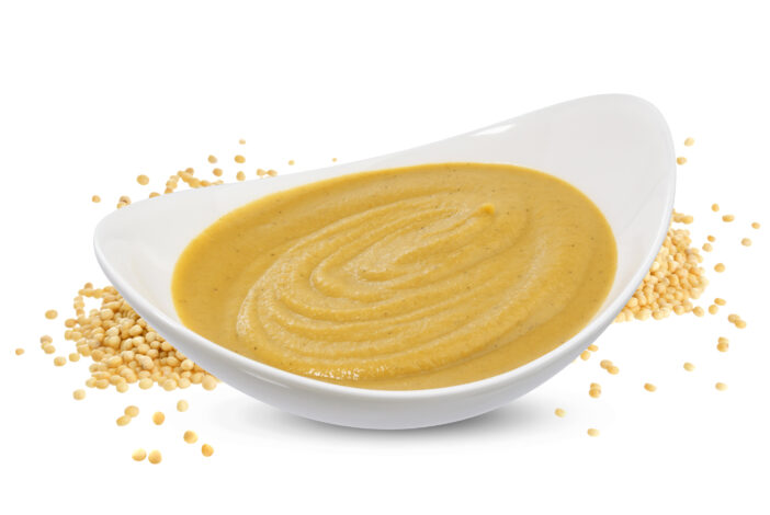 Mustard sauce in bowl and mustard seeds isolated on white background, one of the collection of various sauces