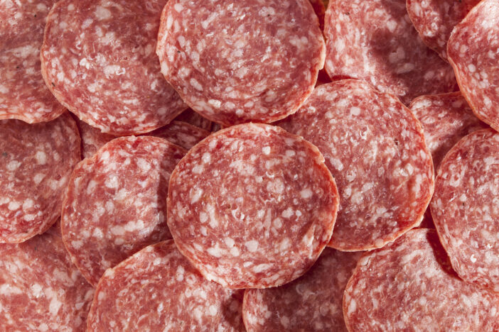 Fresh Cut Organic Salami against a background