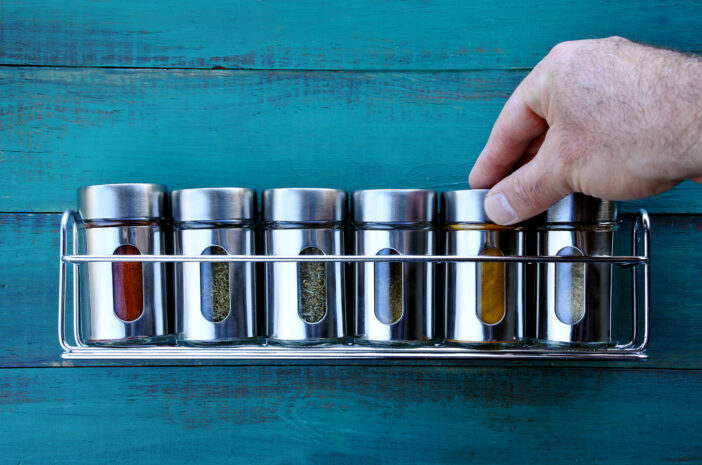 Chef hand returning spice into a spice rack. Food background. copy space