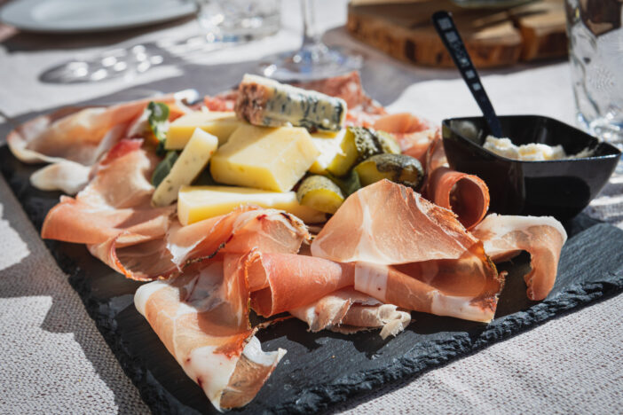 A picture of a plate of speck and typical italian salami with cheese and pickles, Cortina D'Ampezzo, Italy