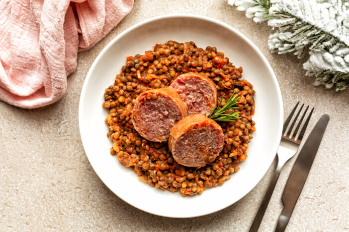 Italian New Year dish Cotechino con lenticchie, Cotechino sausage with Lentils meal, festive food.