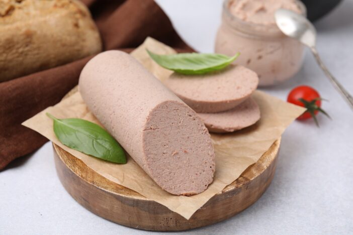 Delicious liver sausages on light grey table