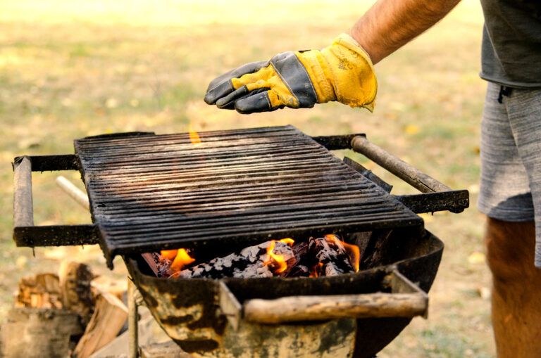 Man hand in glove check barbecue temperature for grilling