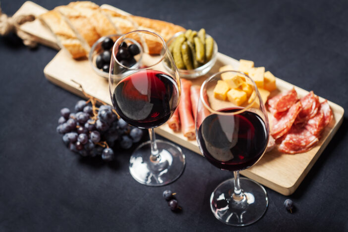 Red wine with charcuterie assortment on the background