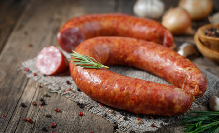 Smoked sausage on a wooden table. Rustic style.