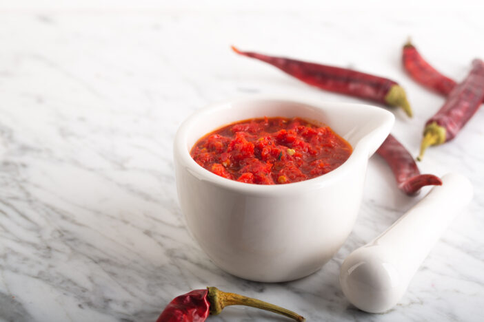 Traditional Maghrebi hot chili pepper sauce paste harissa. Tunisia and Arabic cuisine adjika. Image contains copy space