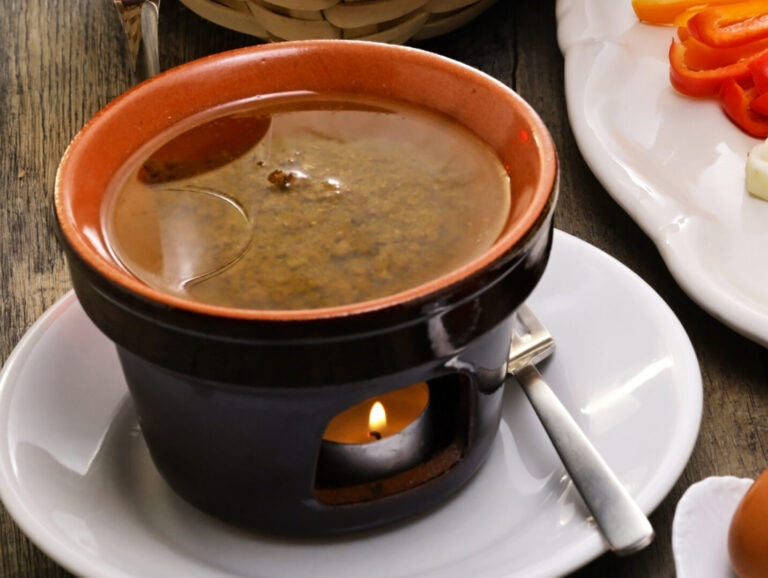 Bagna cauda(Italian Piedmont cuisine)  is a hot dip made from garlic and anchovies. 
The dish is served with raw or cooked vegetables typically used to dip into it.