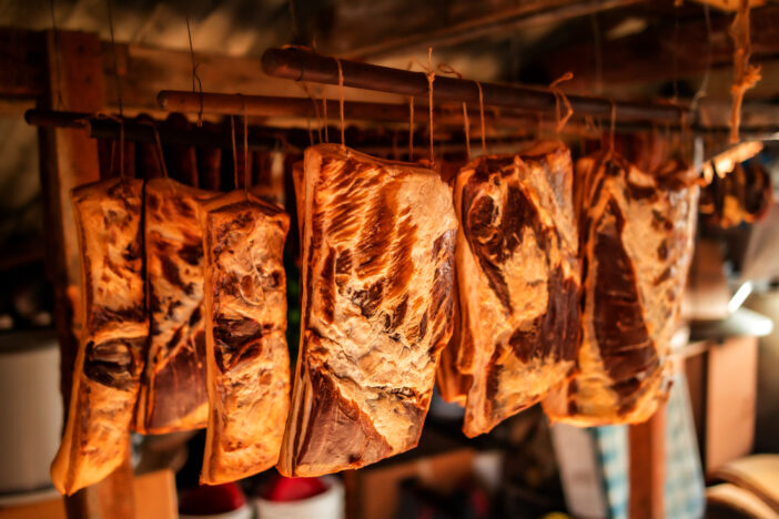 Smoked bacon hanging. Homemade food production.