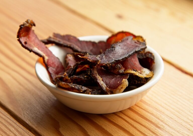 A bowl of traditional South African biltong on a wooden surface