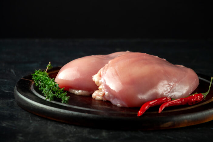 Chicken fillet with spices on a wooden board