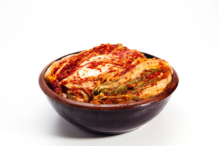 Kimchi in a crock head on white background