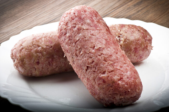 pork sausage (cotechino) with polenta on the wood table