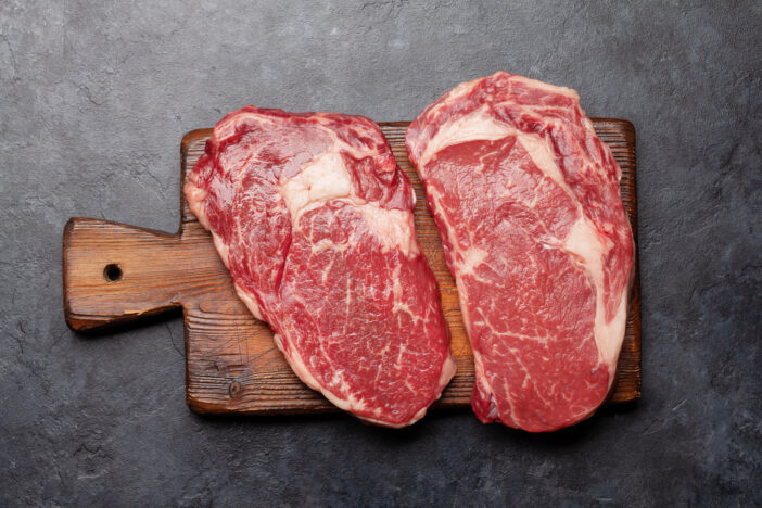 Two raw ribeye beef steaks. Top view flat lay