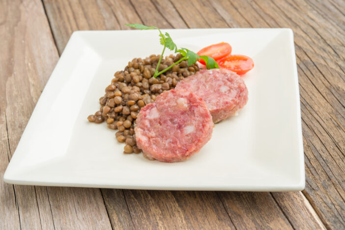 side dish of sausagecotechino  and lentils with parsley and tomato sweet