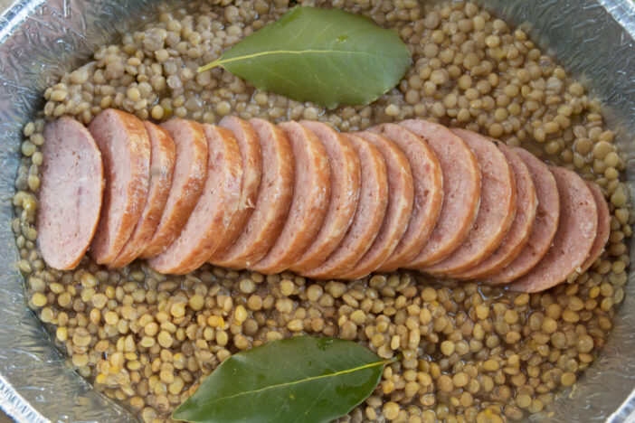 sliced cotechino in lentils soup with bay