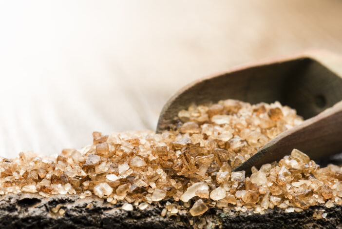 wooden scoop with smoked salt on table