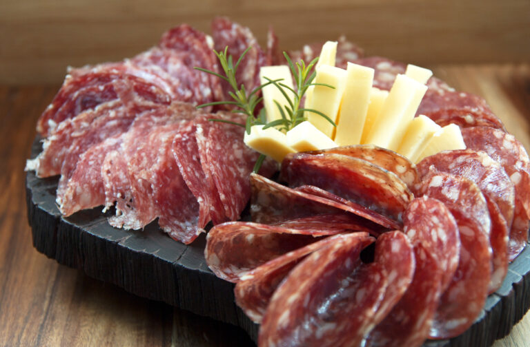 Salami and cheese on wooden board. Appetizers.