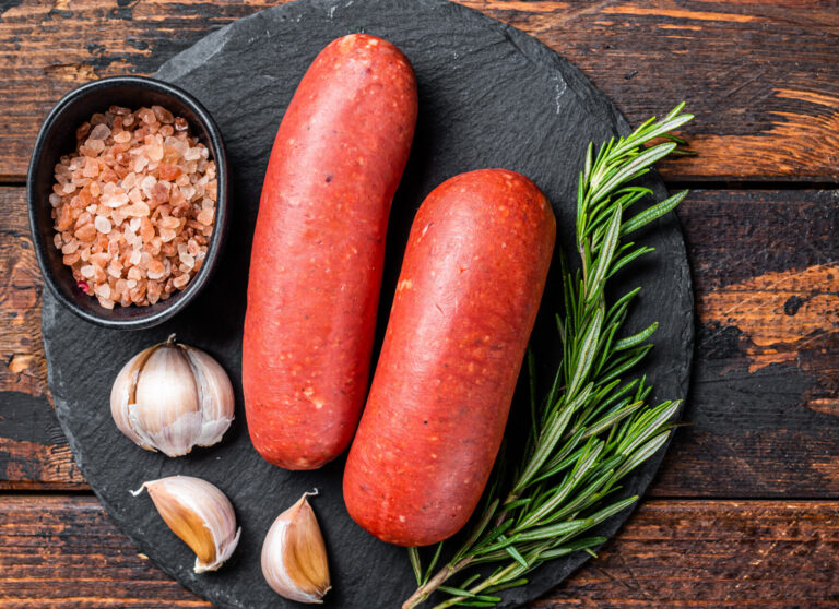 Turkish halal Sucuk meat sausage. Wooden background. Top view. Copy space.