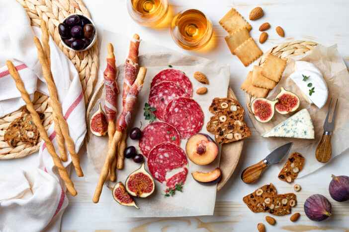 Appetizers table with italian antipasti snacks. Brushetta or authentic traditional spanish tapas set, cheese and meat variety board over wooden background. Top view, flat lay