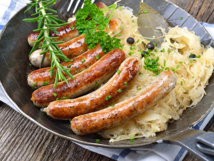 Bavarian fried sausages served with sauerkraut in a pan