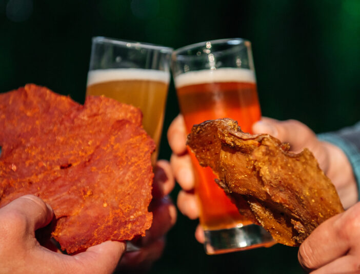 Beer with jerky in hands