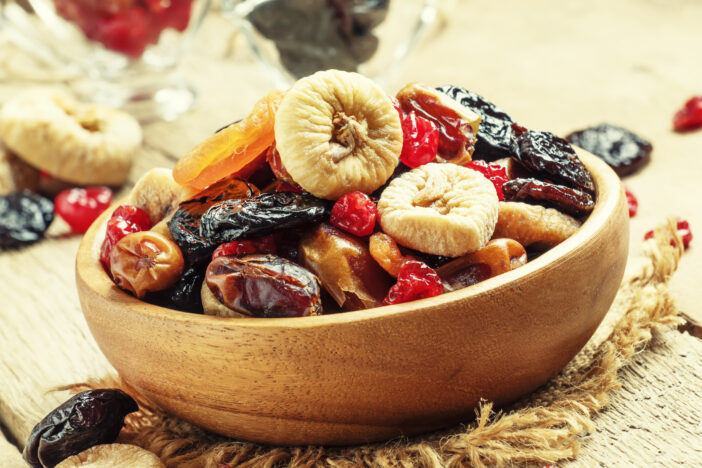 Healthy food: mix from dried fruits in bowl, old wooden background, selective focus