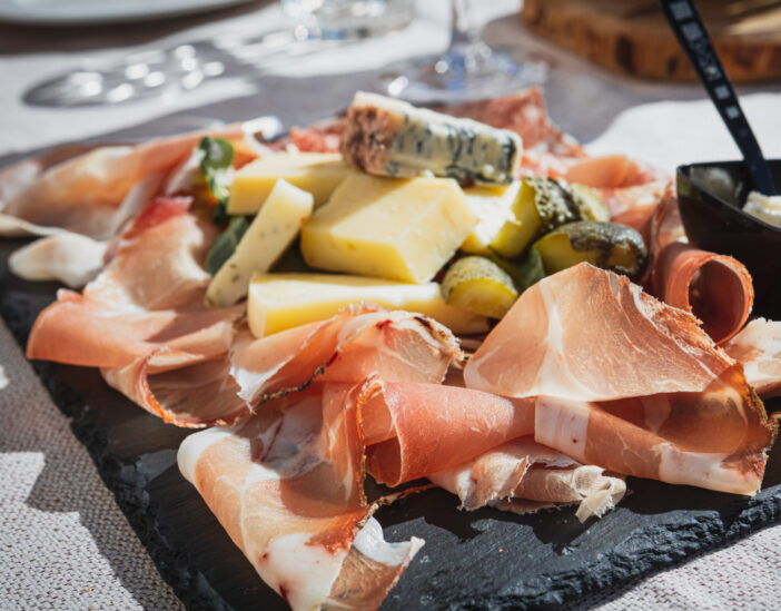 A picture of a plate of speck and typical italian salami with cheese and pickles, Cortina D'Ampezzo, Italy