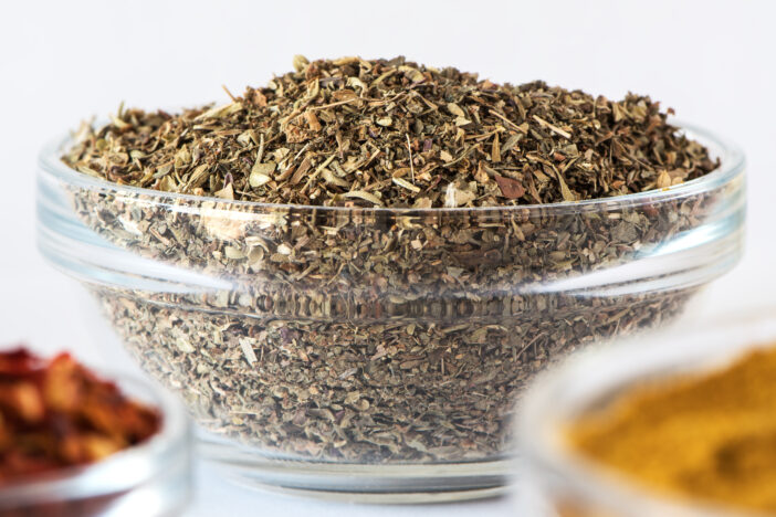 Mix of dry Italian Herbs in glass bowl. Blend of Italian Cuisine. Macro photography