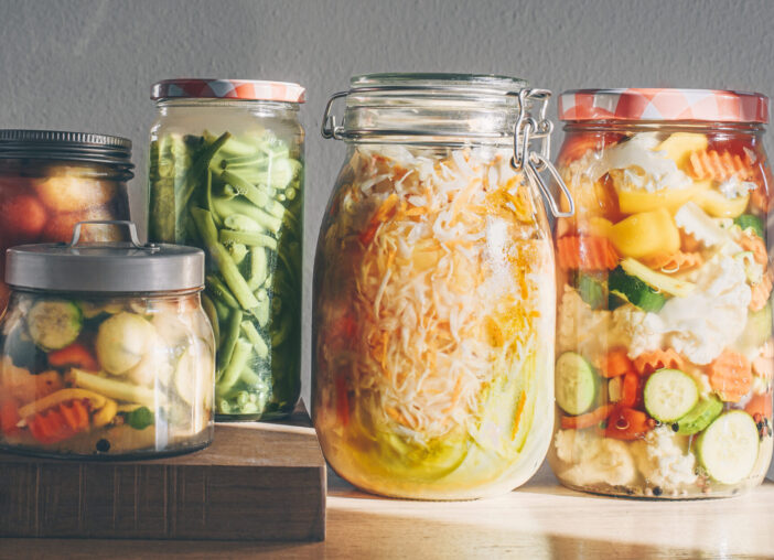 Probiotics fermented food background. Green beans, mixed vegetables , sauerkraut, pickled plums in glass jars. Winter fermented and canning food concept, homemade preparations, home pharmacy. Banner