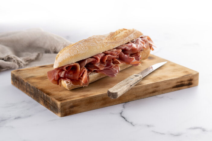 Spanish serrano ham sandwich on marble background