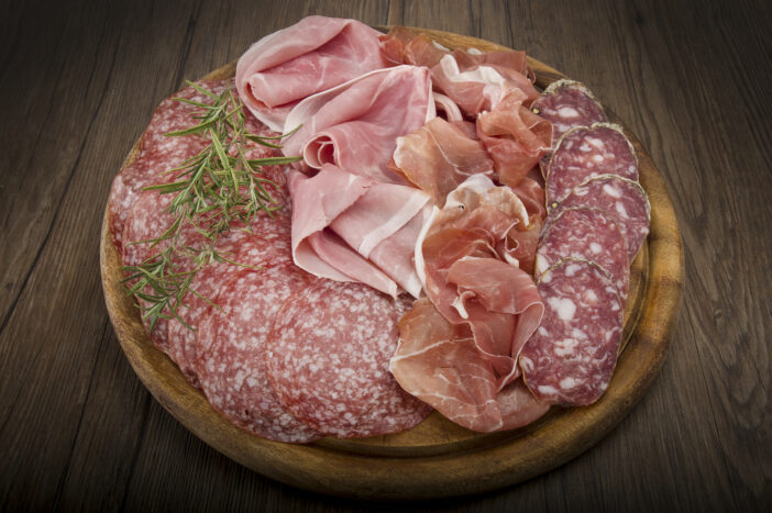 Wooden cutting board with various Italian salami