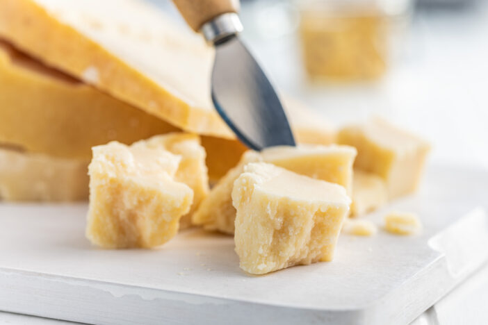 Tasty parmesan cheese on the white table.