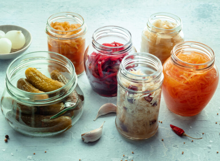 Fermented food. Vegetable preserves. Sauerkraut, pickled cucumbers, kimchi etc in glass jars, with pepper and garlic. Healthy probiotic diet