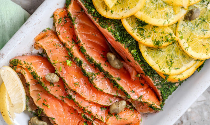 Gravlax - fresh marinated salmon steak in salt and dill on plate. Restaurant menu concept for the New Year.