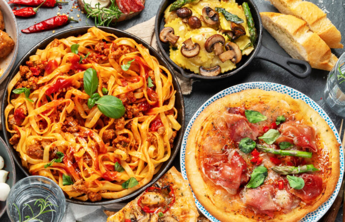 Italian food assortment on dark background. Traditional food concept. Dishes and appetizers of indeed cuisine. Flat lay, top view, panorama