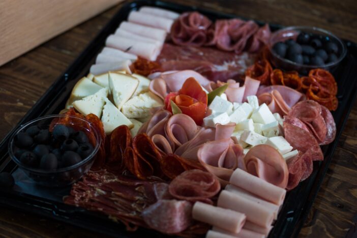 A closeup shot of a table with mix of meats and cheese