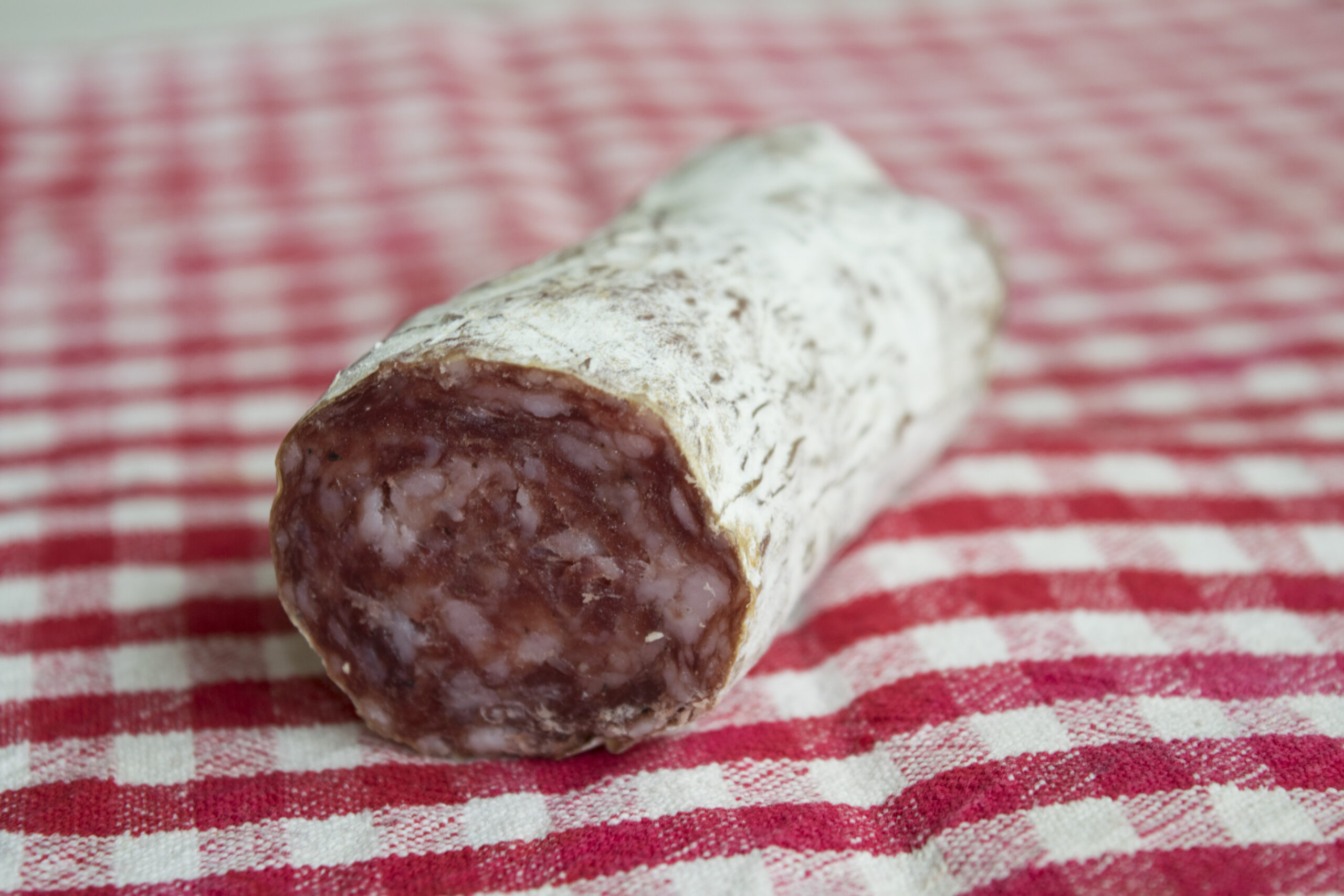 piece of Hungarian salami on a red tablecloth