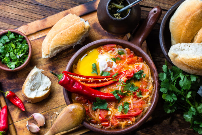 Chilean food. "Picante Caliente" or "spicy hot" with onion, tomatos, chilli aand eggs in tipicacal chilleann cllay pan