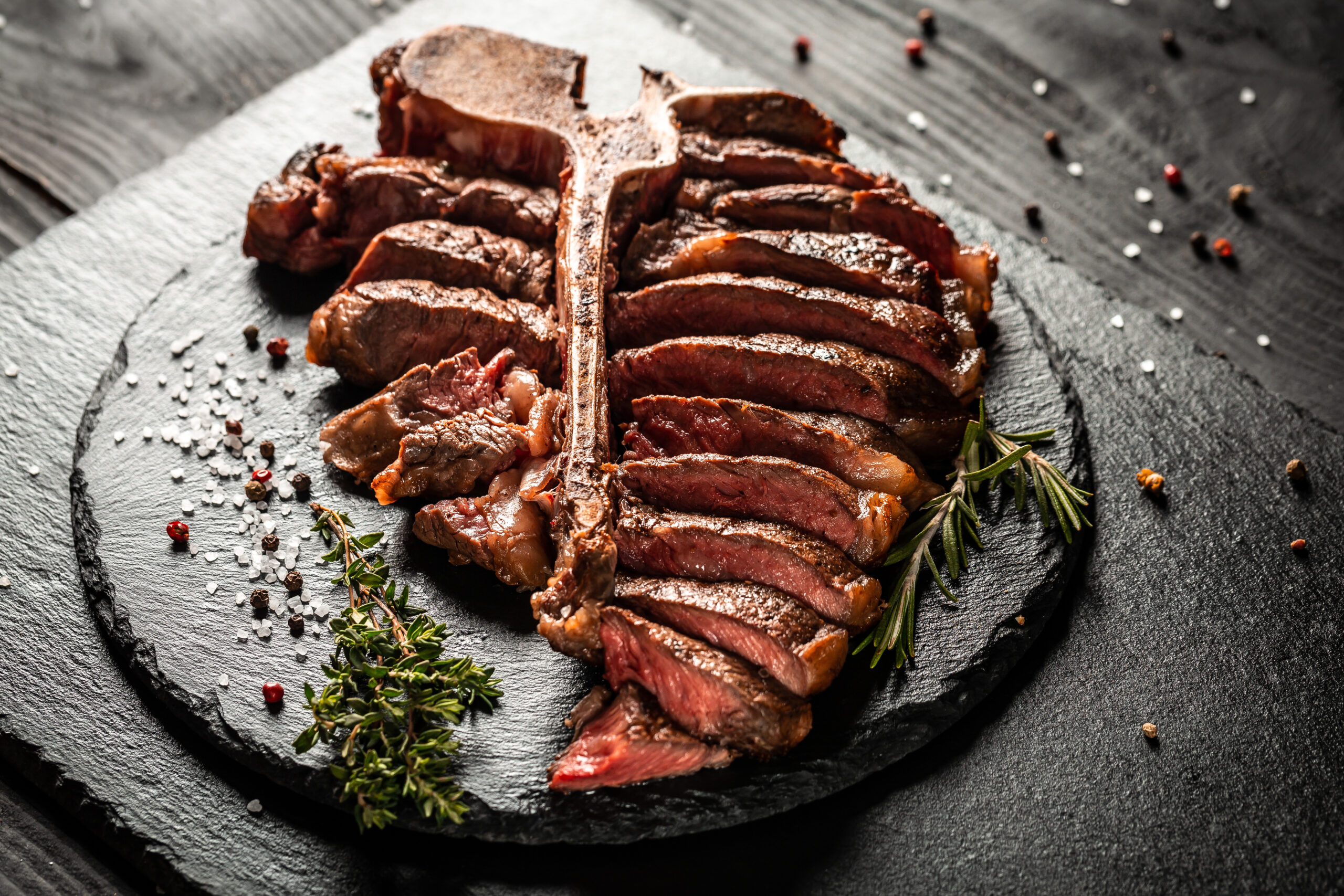 T-bone grilled beef steak. Dry Aged Barbecue Porterhouse Steak. Medium rare. American cuisine. Long banner format, top view.