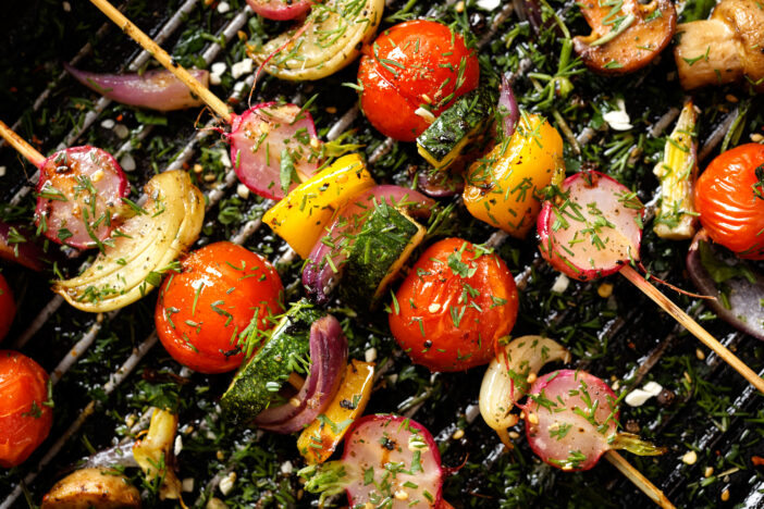 Grilled veggie skewers with cherry tomatoes, radishes, peppers and onions with fresh dill on a grill pan