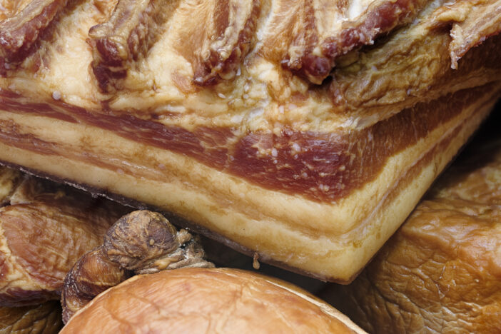 Assorted smoked meat on a market counter, abstract food background