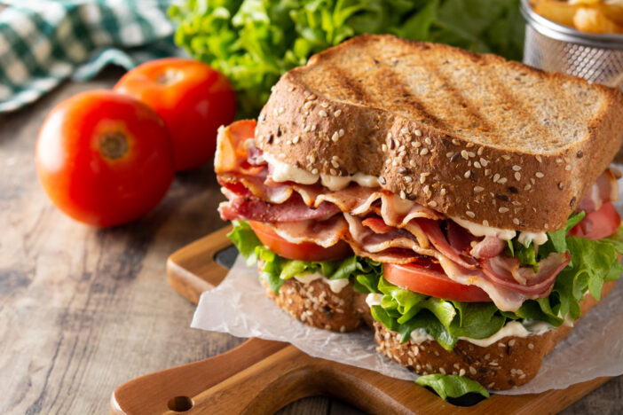 BLT sandwich and fries on wooden table