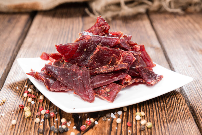 Portion of Beef Jerky on vintage wooden background