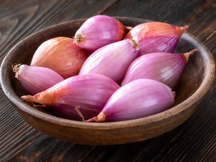 Bowl of shallot onions on the wooden background