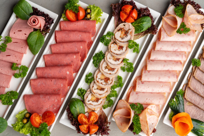 Platter of fresh meat cold cuts on table, close up